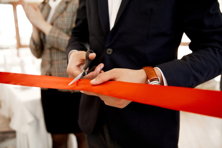 Front view of the cutting the red ribbon on the grand opening of